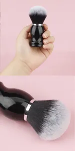 Large round makeup brush detail view showing soft gradient bristles and ergonomic black handle.