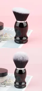 Large round makeup powder brush with ergonomic black handle and soft synthetic bristles.