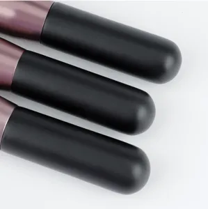 Detailed close-up view of cosmetic makeup foundation brushes with black matte handles and metal ferrules.