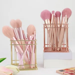 Professional makeup brush set with elegant pink bristles and metal wire storage holder.