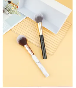 Detail view of marble handle makeup brush with soft synthetic bristles and sleek gold ferrule.