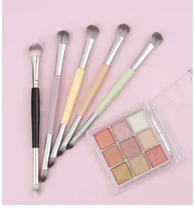 Detailopname van dubbelzijdige make-up penselen set en 9-kleuren oogschaduwpalet close-up.