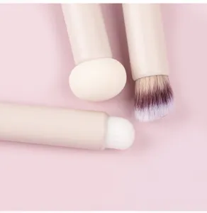 Close-up detail of multi-functional makeup brushes with sponge puff and soft bristle heads.