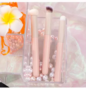 Detail shot of pink mini concealer brushes in clear pearl organizer for flawless makeup application.