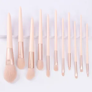 Set di 11 pennelli trucco professionali con setole morbide e manici rosa in stile elegante.