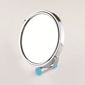 Detailed view of round stainless steel desktop makeup mirror with blue silicone stand support.