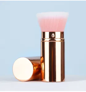 Portable retractable makeup brush detail, rose gold casing with soft pink bristles.