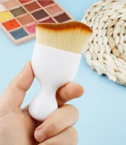 Detail shot of the wave-shaped curved foundation brush with soft bristles and white handle.