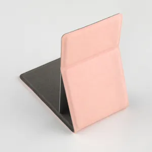 Portable folding makeup mirror in pink leather with dark grey stand for desktop use details.