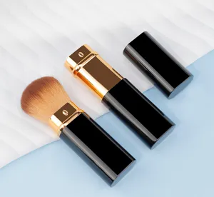 Detailed shot of portable square retractable makeup brush with black and gold finish.