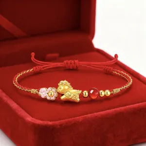 Primer plano detallado de la pulsera de cordon rojo con dije de caballo dorado zodiacal.