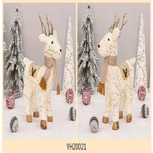 Decorazione con statuetta di renna in peluche di Natale con corna dorate e sciarpa festiva.