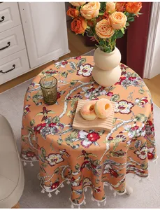 Detailed view of American style round fabric tablecloth with vintage floral pattern and tassels.
