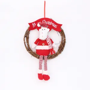 Couronne de décoration de Noël suspendue avec poupée en peluche et bannière rouge.