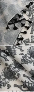 Detailed close up shot of linen curtain fabric featuring black tassels and print pattern.