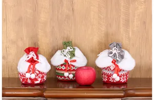 Nahaufnahme gestrickter Weihnachts-Apfeltaschen mit Plüschrand für festliche Geschenke und Deko.