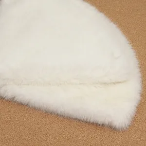 Close-up detail view of white faux fur Christmas tree skirt, soft plush holiday decor mat.
