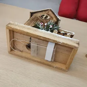 Houten kerst verlicht huis ornament detail toont batterijdoos en bedradingsstructuur.