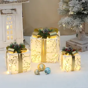 Weihnachtliche leuchtende Geschenkboxen 3er-Set mit warmem Licht und goldenen Schleifen als Deko.