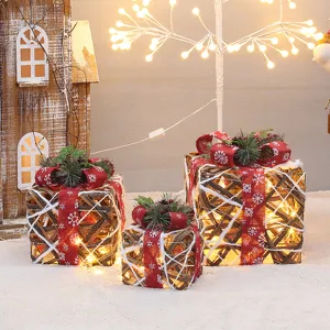 Weihnachtsset aus Naturrattan Geschenkkartons mit warmen Lichtern und rotem Schleifenband.
