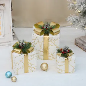 Weihnachtliche beleuchtete geschenkboxen set, pluesch oberflaeche mit goldener schleife fuer deko.