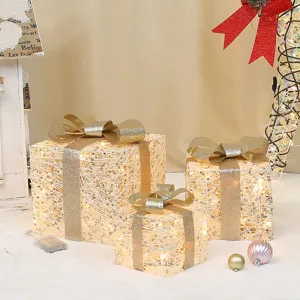 Detailed view of glowing Christmas gift box set with warm LED lights and glitter bows for decor.