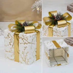 Dekorative Weihnachts-Geschenkbox mit goldener Schleife, Tannenzapfen und Plüschstoff.