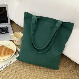 Detailansicht einer dunklen grünen Stofftasche aus Canvas in gemütlicher Zimmerkulisse.