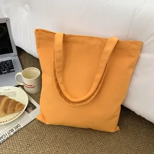 Detailansicht der leuchtend orangefarbenen Canvas-Tragetasche mit gemütlichen Requisiten.