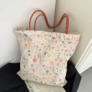 Stofftasche mit Blumenstickerei, großer Kapazität und bunten Henkeln im Detail.