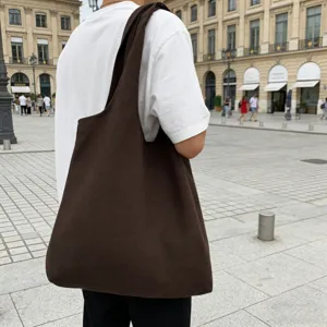 Detailansicht der lässigen dunkelbraunen Canvas Schultertasche im Freien auf dem Platz.