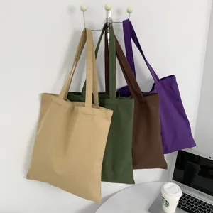 Detailansicht farbiger, lässiger Canvas-Tragetaschen an Wand, perfekt für tägliche Nutzung.