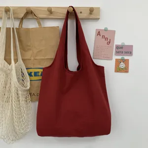 Dunkelrote Segeltuch Schulter-Tragetasche hängend Detail in minimalistischem Zimmer Szene.