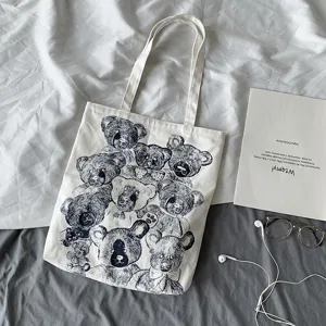 Detailed view of canvas tote bag featuring vintage teddy bear print on textured fabric.