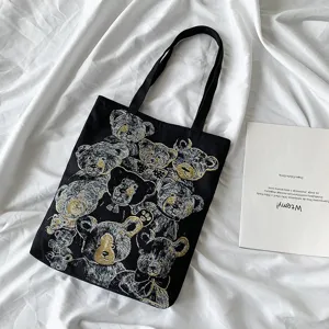 Black canvas tote bag with vintage teddy bear graphic print. Stylish casual shoulder bag.