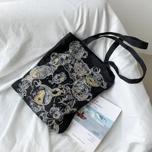 Black canvas tote bag detail featuring artistic vintage bear print pattern and sturdy shoulder straps.