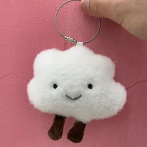 Close-up of cute white cloud plush bag charm with little brown legs and steel ring.