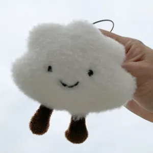 Detailed shot of cute white plush cloud pendant with brown cute legs, fluffy texture and bag accessory.
