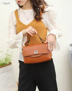 Stylish women's leather handbag and crossbody bag with metal lock design for daily commuting.