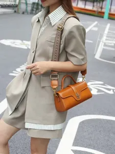 Vintage genuine leather shoulder bag for women, stylish top handle crossbody bag with wide strap.