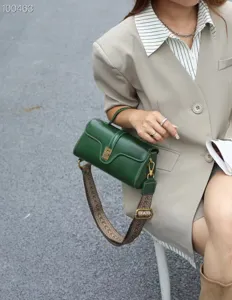 Detail view of genuine leather retro green cylindrical shoulder crossbody bag for women.