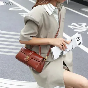 Vintage genuine leather shoulder bag for women, stylish brown crossbody pillow bag with metal lock.