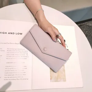 Elegant purple long leather wallet for women with envelope snap closure and pebble grain design.