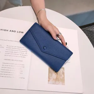 Blue genuine leather long envelope wallet detail showing soft pebble texture and snap button.