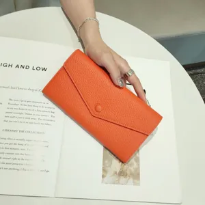 Orange leather long wallet for women, elegant envelope design with snap closure. Premium texture.
