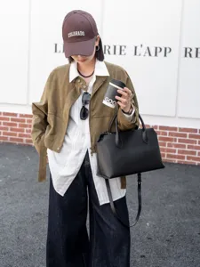 Detailansicht der großen schwarzen Leder-Tote-Bag, klassischer Pendler-Stil mit Doppelgriffen.