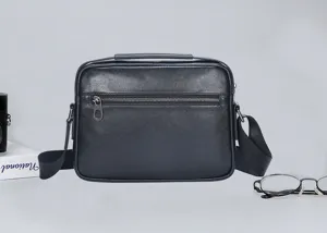 Vista detallada de bolso cruzado para hombre en cuero genuino negro con cremallera.