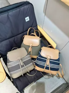 Vue détaillée de trois mini sacs à dos élégants en toile et cuir avec fermeture à rabat.
