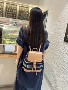 Vue détaillée du sac à dos en toile, rabat en cuir marron et tissu bleu, sac de voyage.