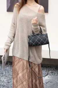 Chic black shoulder crossbody bag for women, niche design pillow bag with white stitching details.